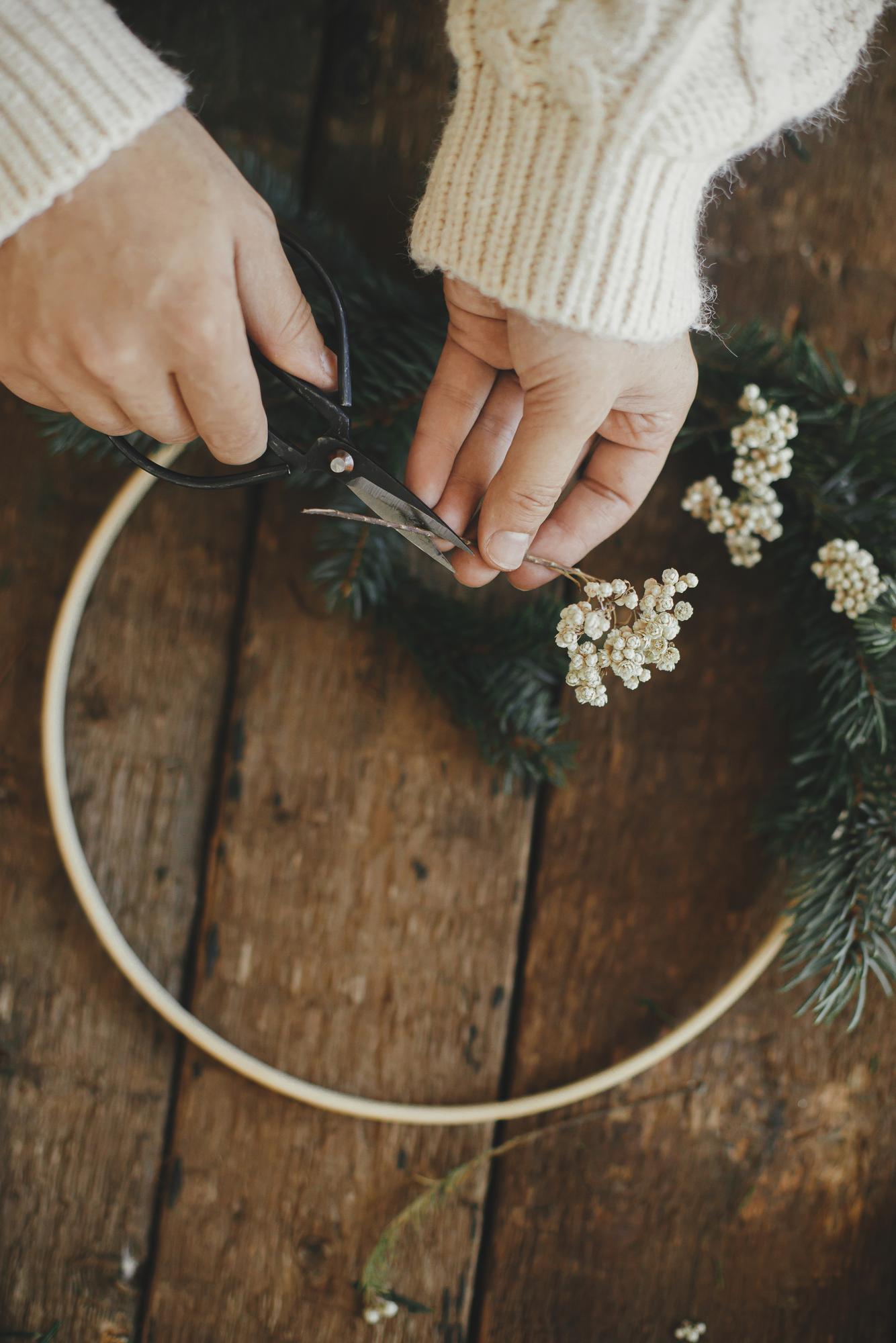 Hands at work embroidering a hoop with floral design