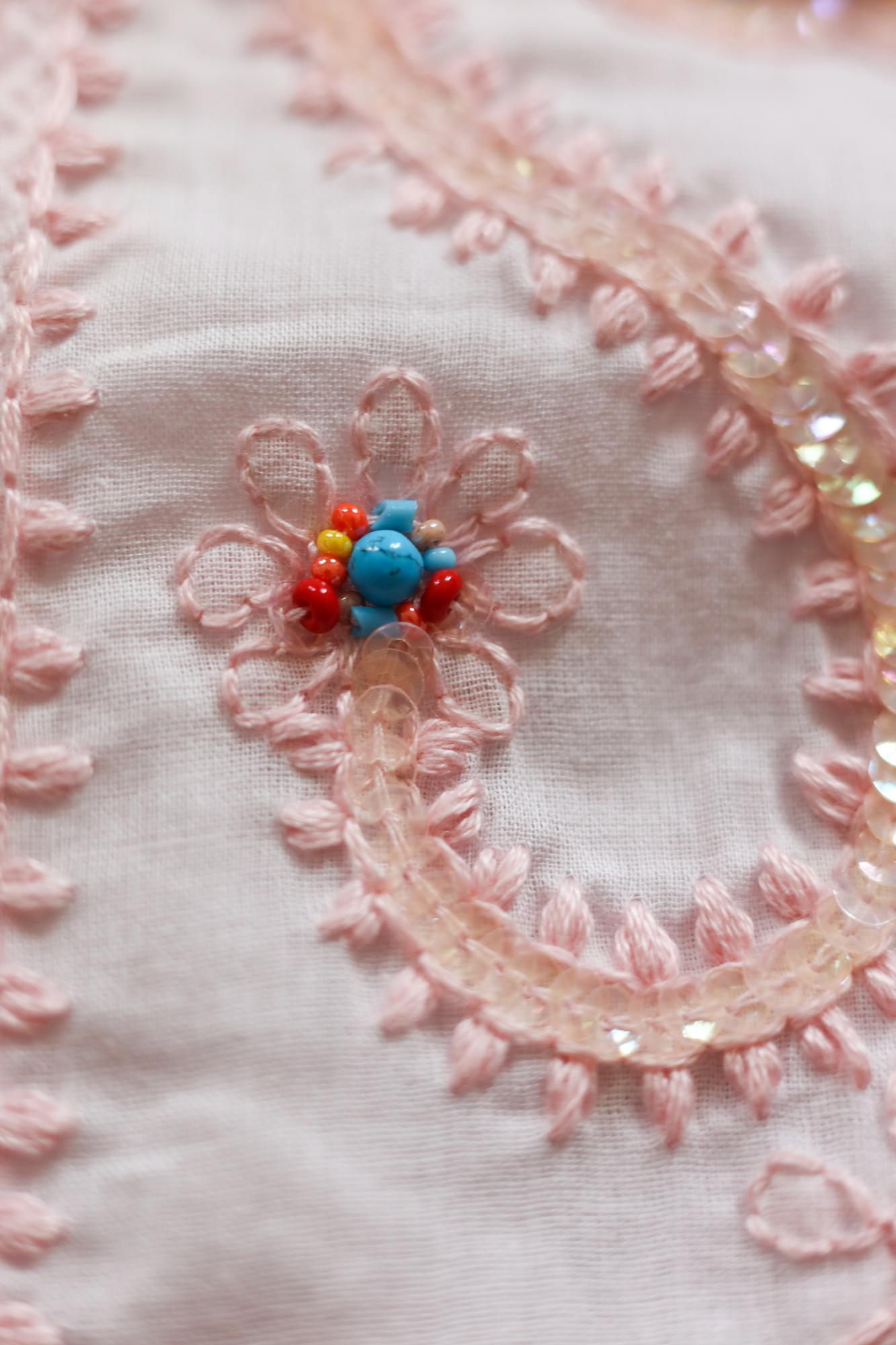 Close-up of pastel embroidered floral motif on linen